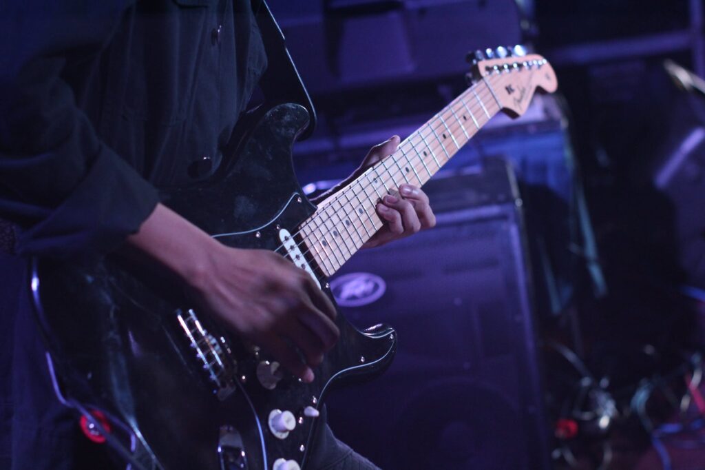 person using black fender stratocaster