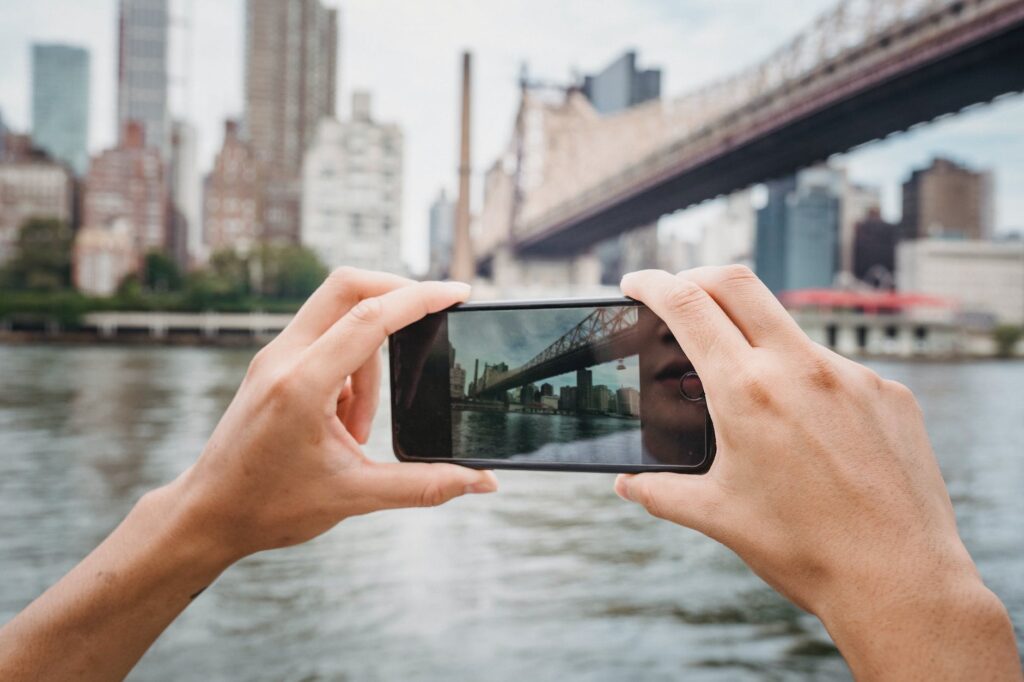 anonymous person photographing city with smartphone