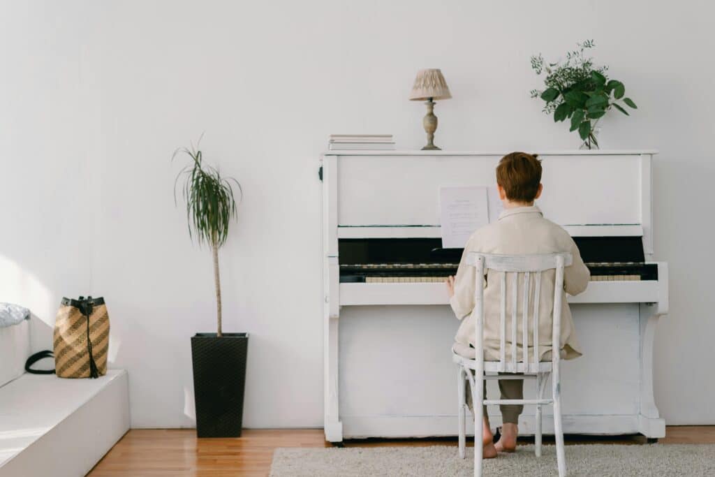 Photo by Mikhail Nilov: https://www.pexels.com/photo/boy-in-white-long-sleeves-sitting-on-a-chair-playing-piano-7570103/