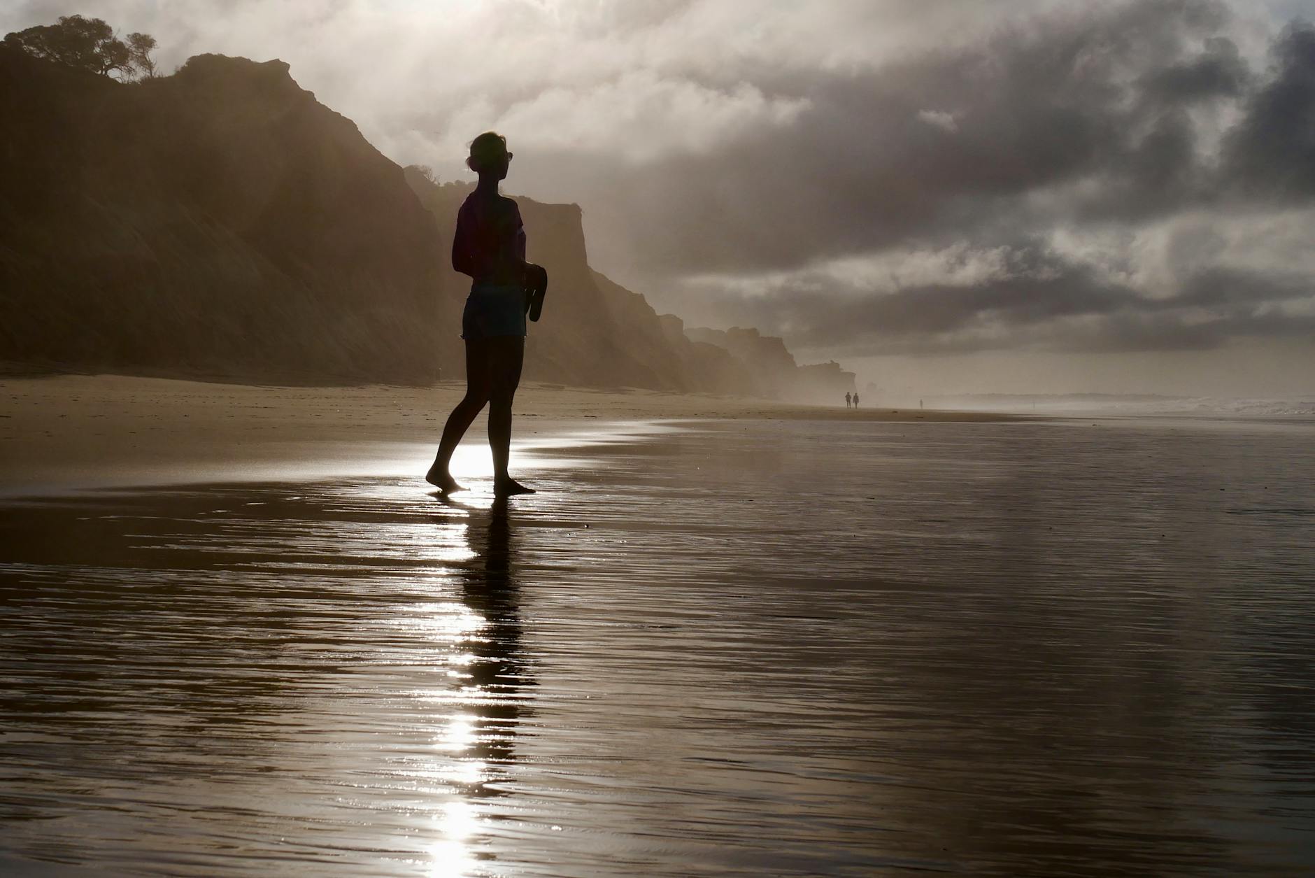 silhouette of woman at sunset on algarve beach